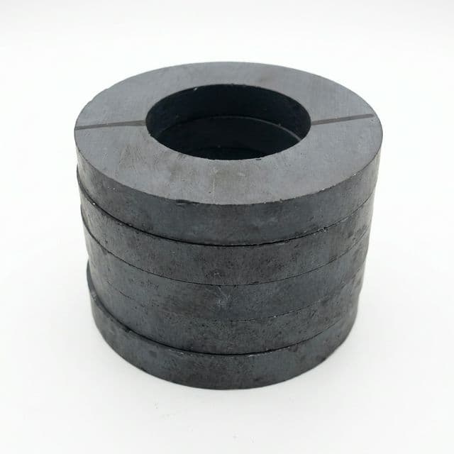 Large ferrite ring magnets stacked for industrial motor and speaker assemblies.
